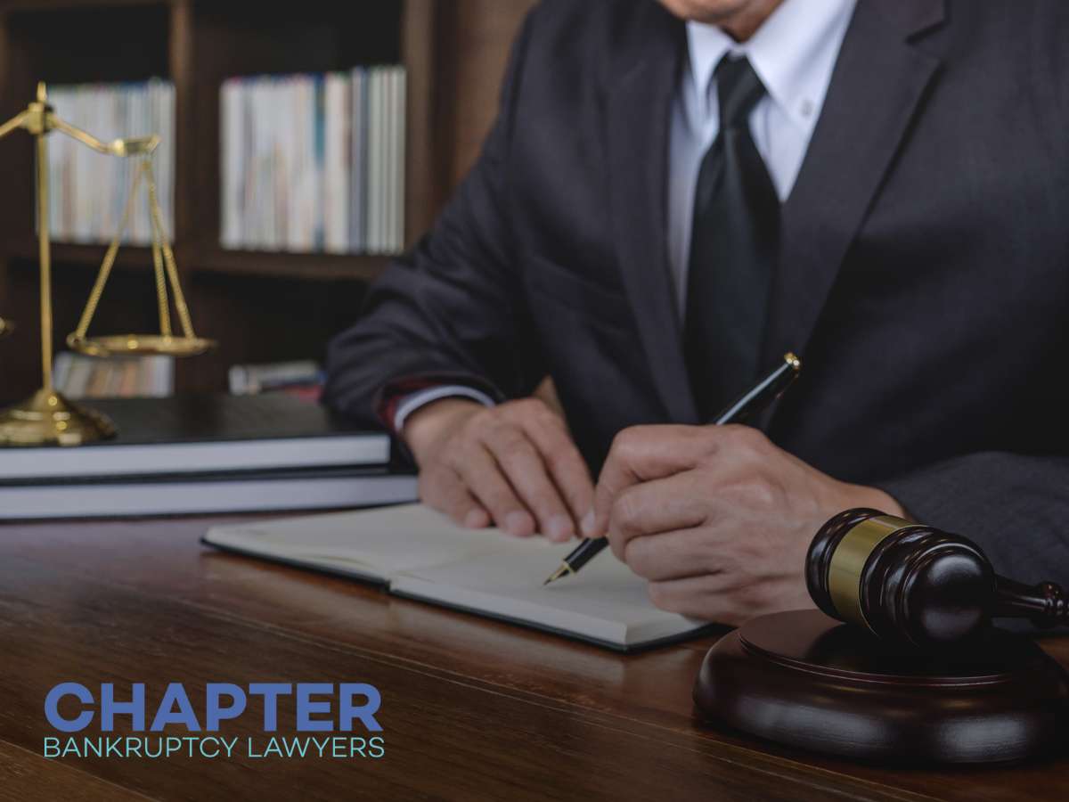 Chapter Bankruptcy Lawyers consulting at a desk, with legal books and a gavel in the background.