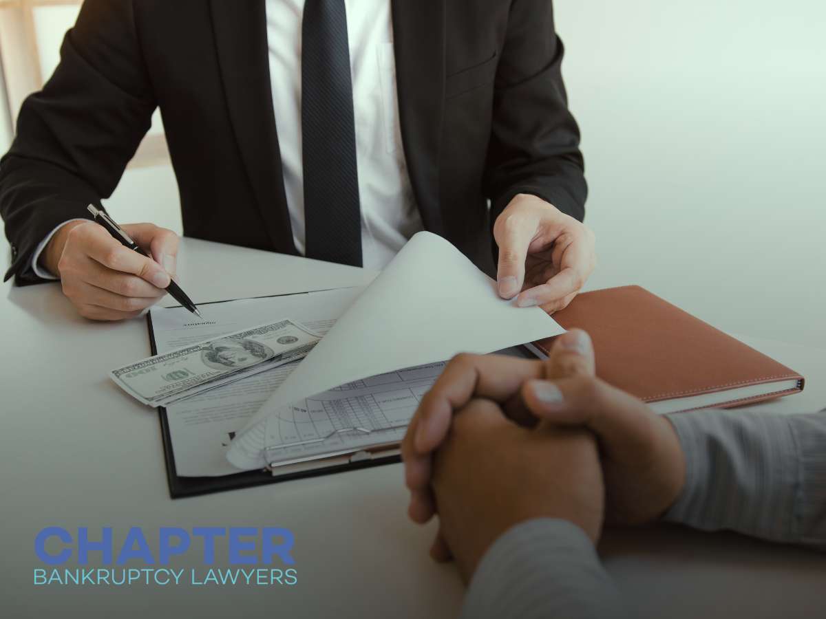 Bankruptcy lawyer reviewing financial documents and discussing debt relief