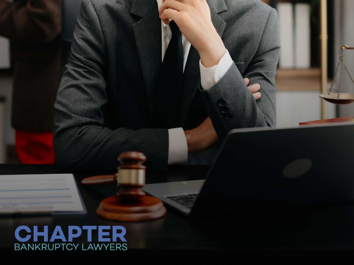 A lawyer in a suit sits at a desk with a gavel and laptop, representing legal services as an Arizona local pizza chain declares bankruptcy.